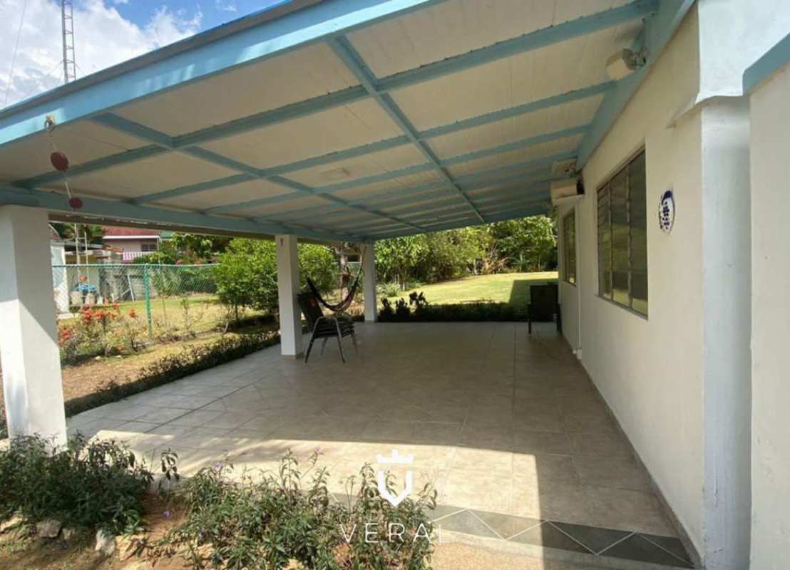 Exterior of renovated two-story Canal Zone historic bungalow with garden and terrace Panama