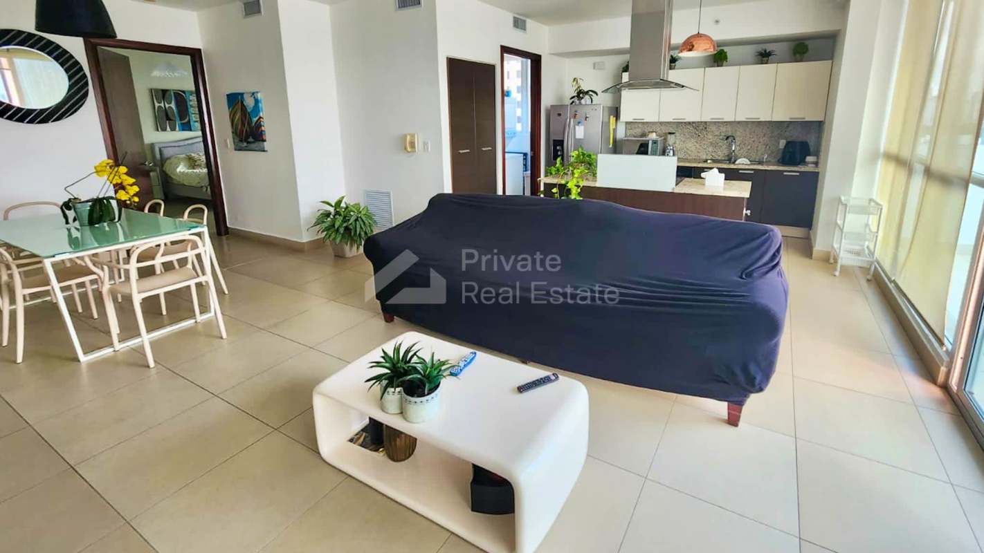 Modern open kitchen and living room with floor-to-ceiling windows and city views at PH Oceania Panama