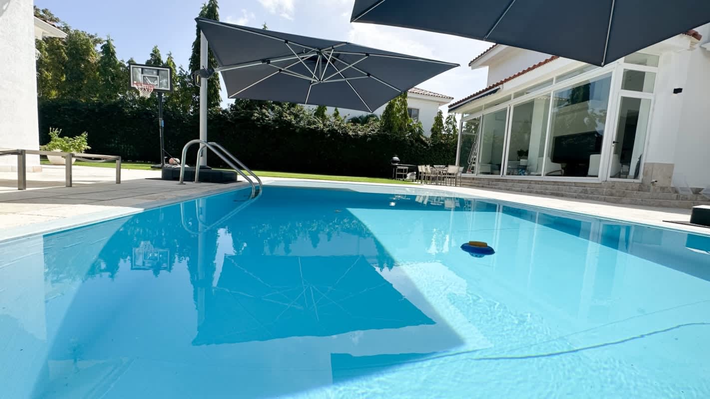 Private swimming pool surrounded by gardens and patio in Santa María luxury home Panama City