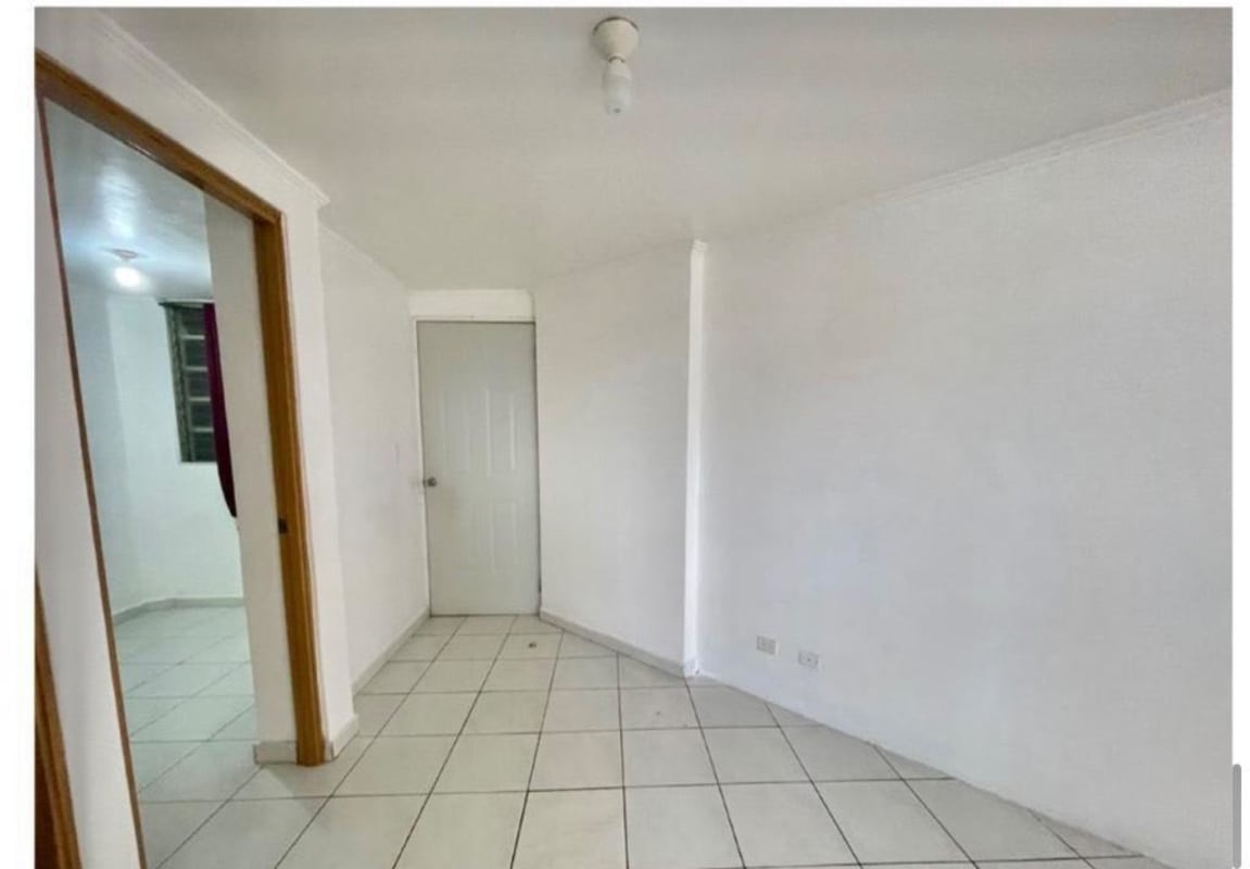 Simple tiled-floor hallway transition space inside PH Llano Bonito apartment in Panama City