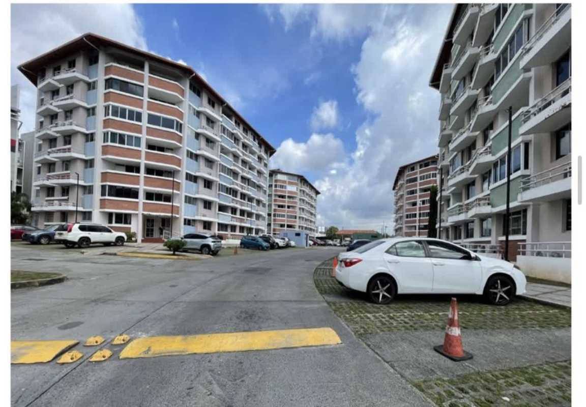 Residential apartment buildings with parking and road under blue sky at Llano Bonito Panama