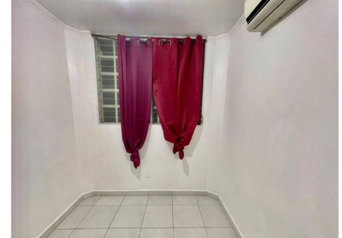 Minimalist bedroom with window bars and AC unit in PH Llano Bonito apartment Panama City