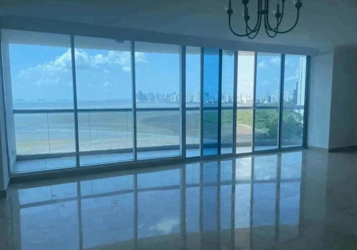 Bright living area with marble floors, large balcony with ocean and city skyline views in PH Pearl at the Sea Panama