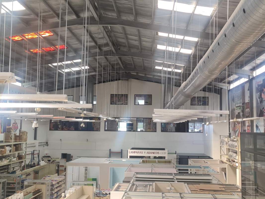 Spacious industrial-style showroom with exposed ductwork, large open floor and double-height ceiling in Panama City