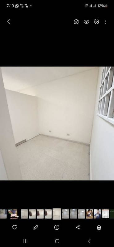 Small office room with large window, natural light, white walls at PH Torre Avenida Perú