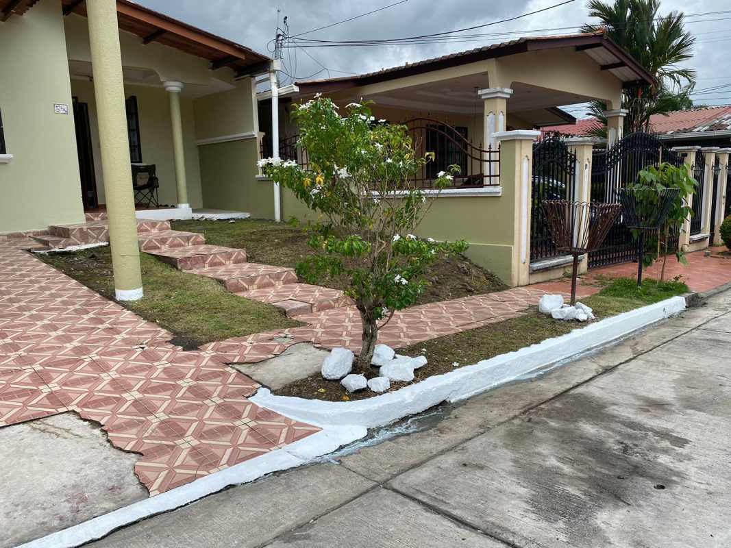 Covered porch with pillars and front garden in Brisas del Golf Panama single-family house