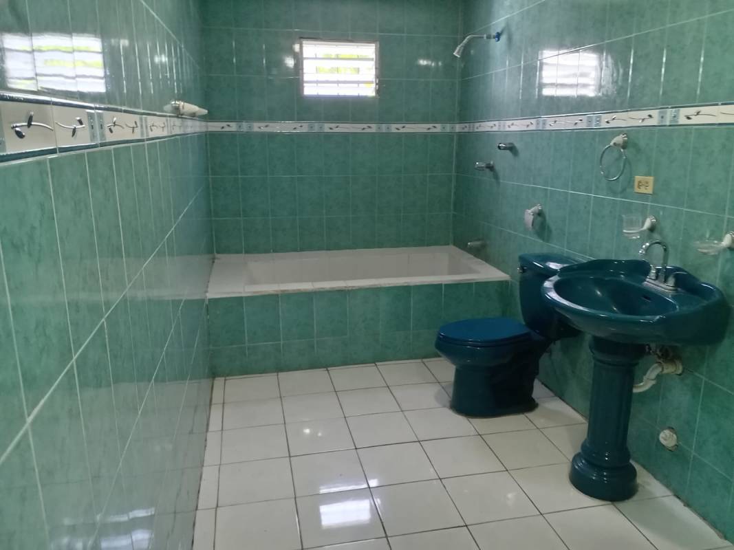 Simple back exterior view with three doors under corrugated metal roof Urbanización Don Bosco Panama