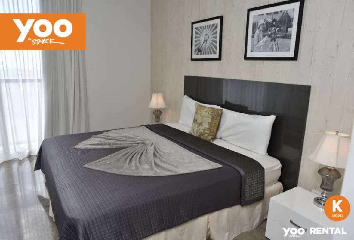 Bedroom with large bed, accent wall, bedside tables, and city views from floor-to-ceiling window in PH Yoo Panama