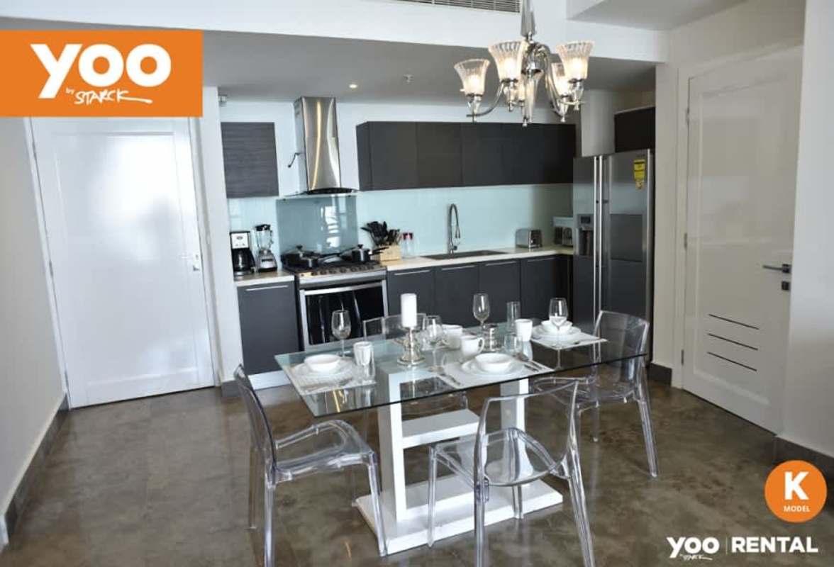 Open concept kitchen and dining with modern cabinetry, glass backsplash and contemporary chandelier at PH Yoo Panama