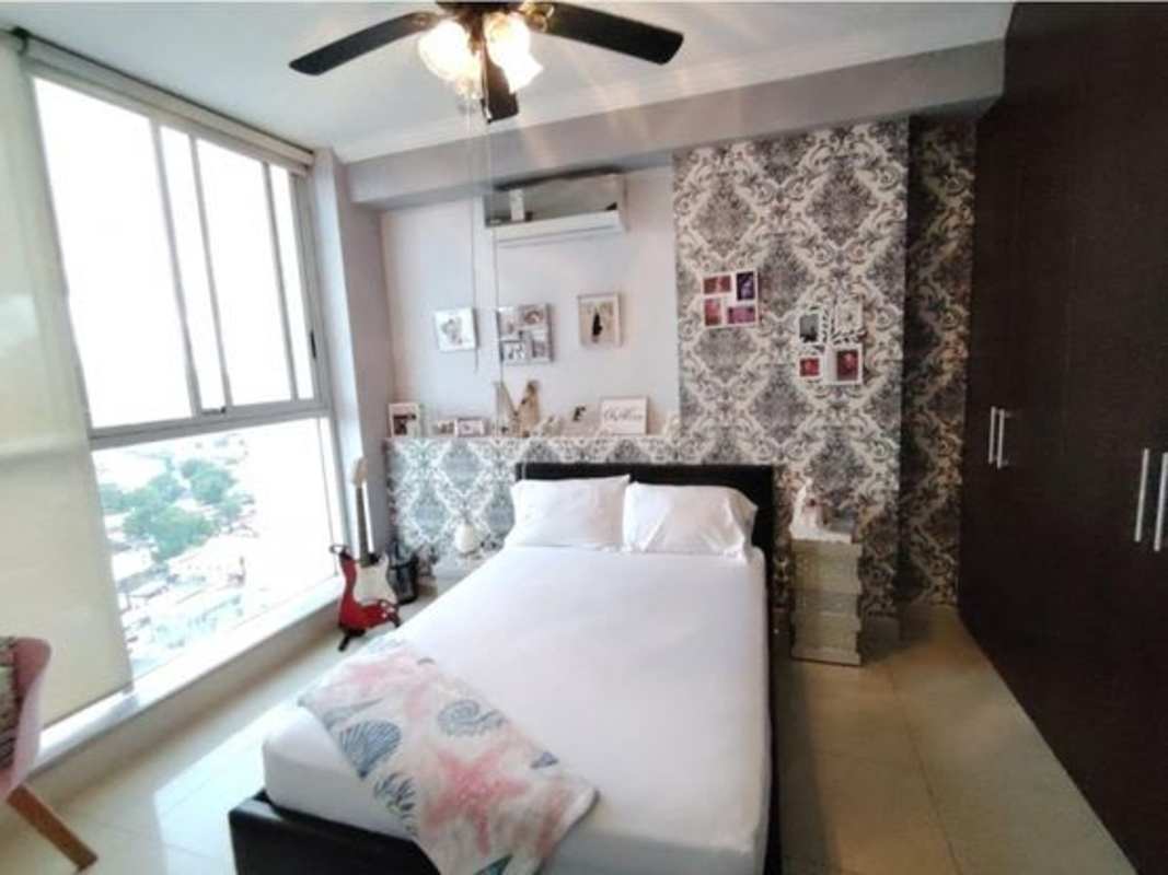 Modern bedroom featuring large window, wallpaper accent wall PH Windows San Francisco Panama