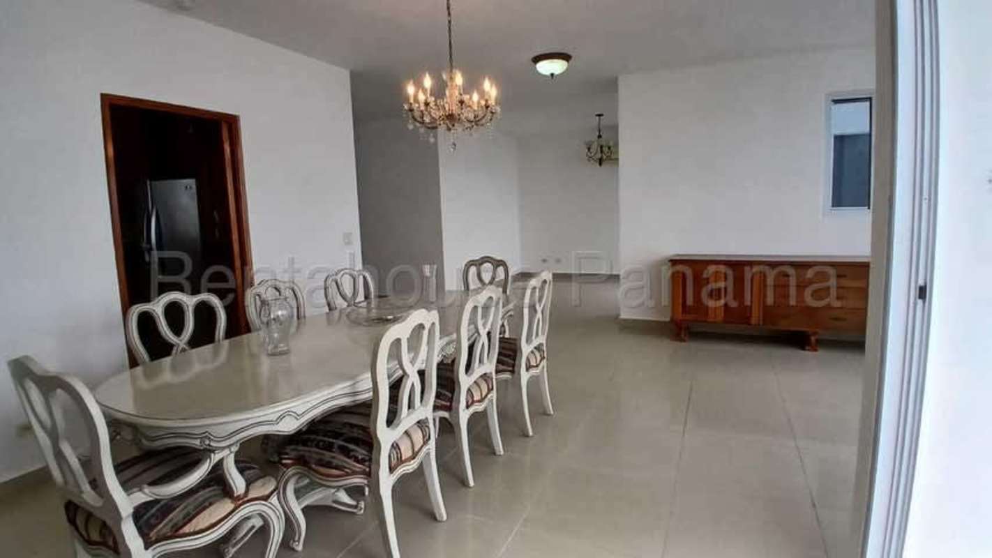 Formal dining room with chandelier adjacent to large windows in PH Mandarin Bay Panama