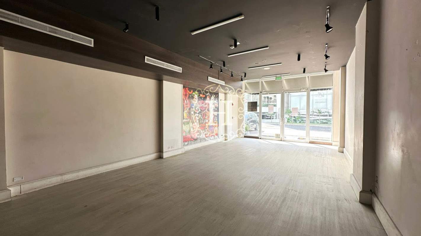 Shopping plaza exterior with multiple store units, parking area and modern glass facades in San Francisco Panama City