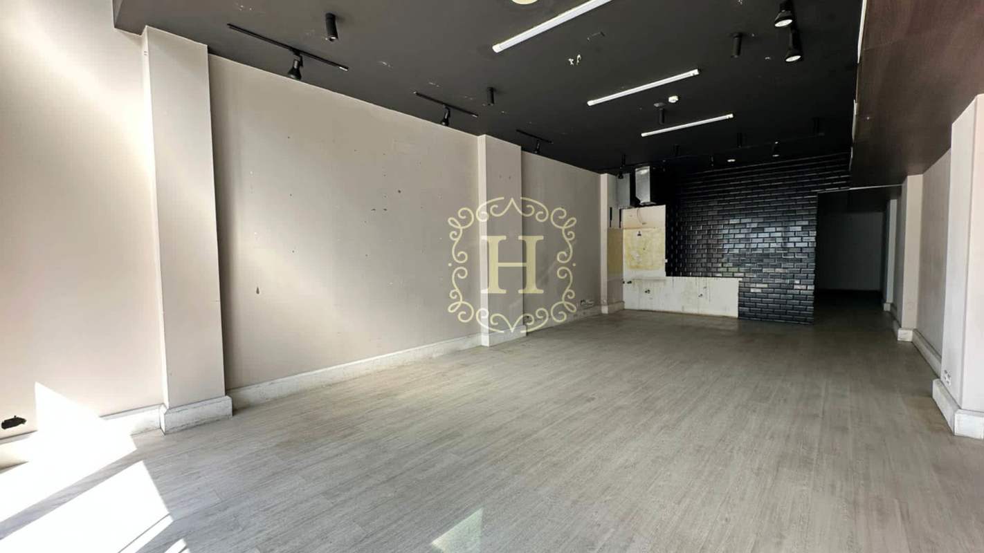 Empty commercial retail space with light wood flooring, track lights, and black ceiling in San Francisco Commercial Plaza Panama