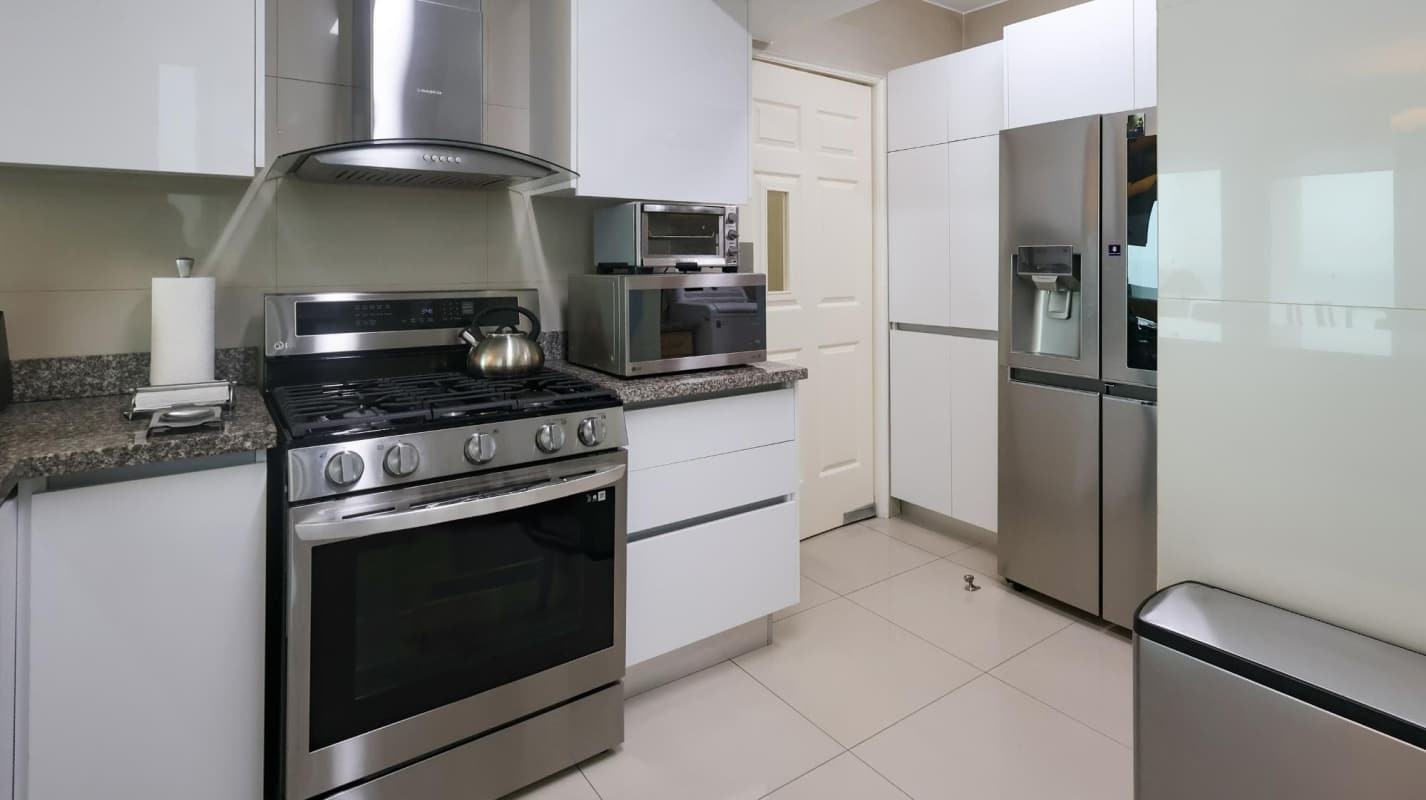 Kitchen with granite countertops, stainless steel appliances, and white cabinets at PH Prive Tower Panama City
