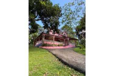 Traditional Spanish-style villa facade pink tone with garden and balcony in Colon Panama