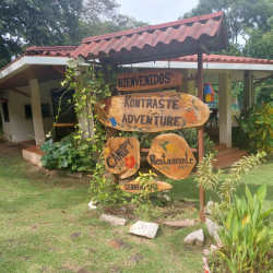 Outdoor rustic building with wooden signpost in lush garden view La Chorrera