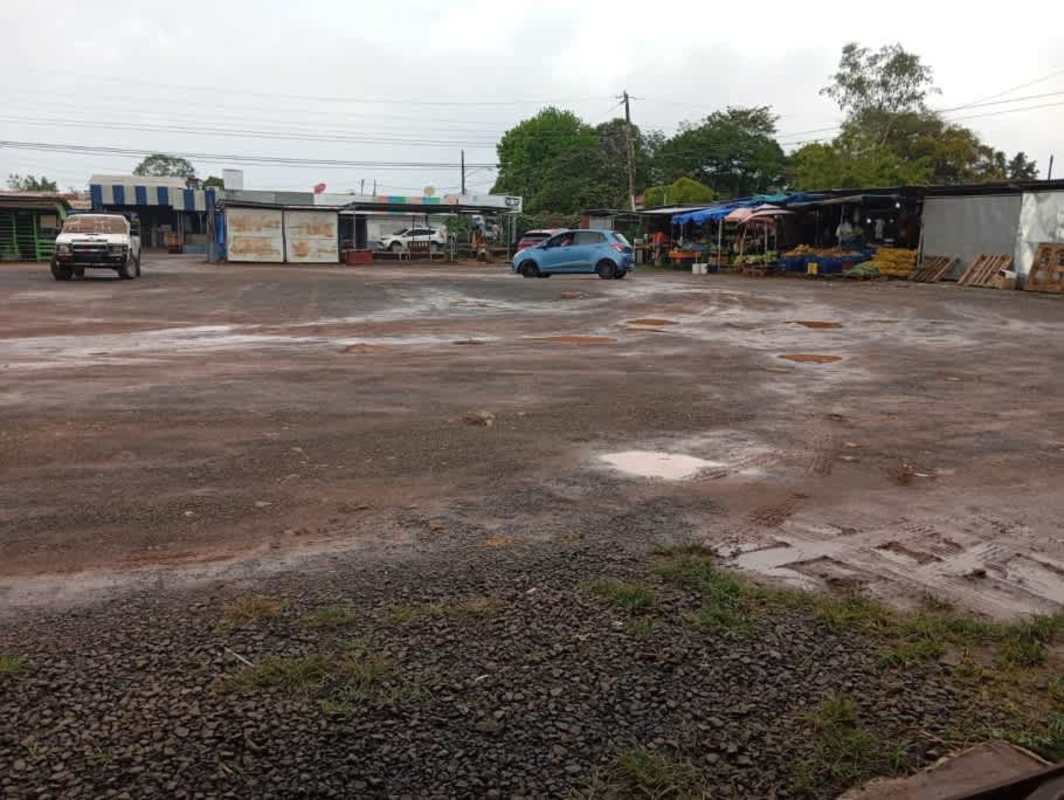 Outdoor market stalls with gravel parking on commercial lot in La Chorrera Panama