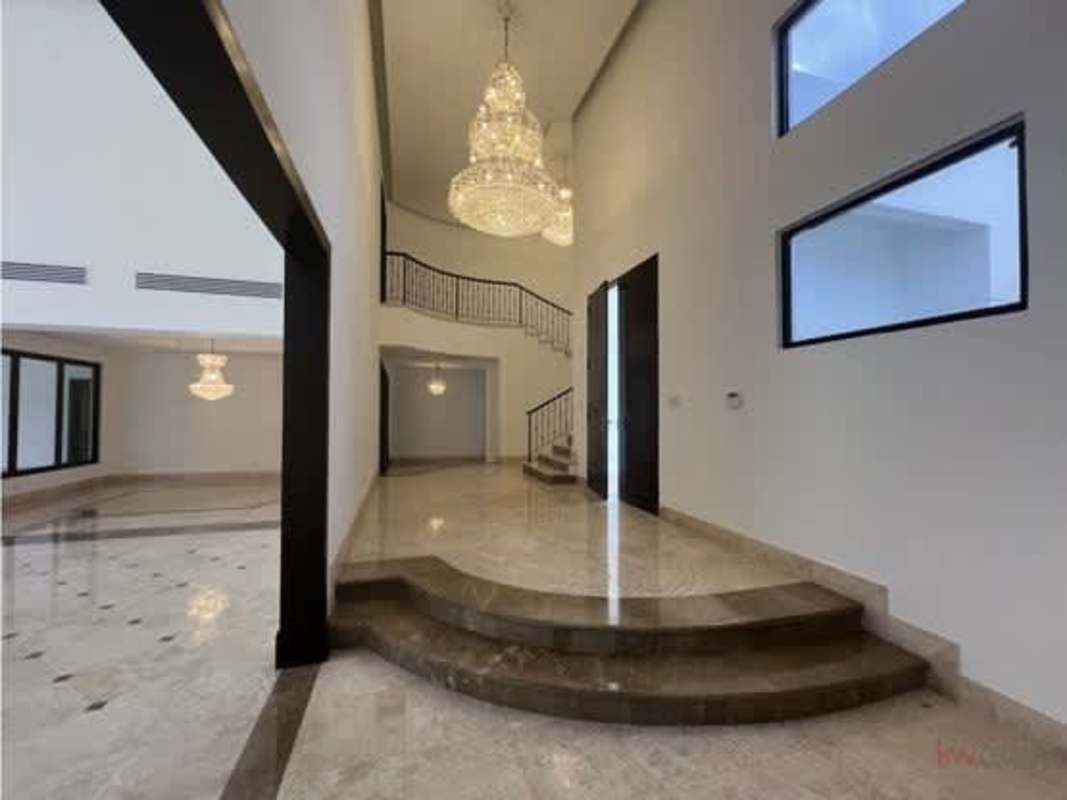 Spacious kitchen with island, dark wood cabinets and marble countertops in Costa del Este Panama