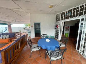 Rustic outdoor BBQ area with ocean views, brick columns, hammocks in PH Villas del Farallón Panama
