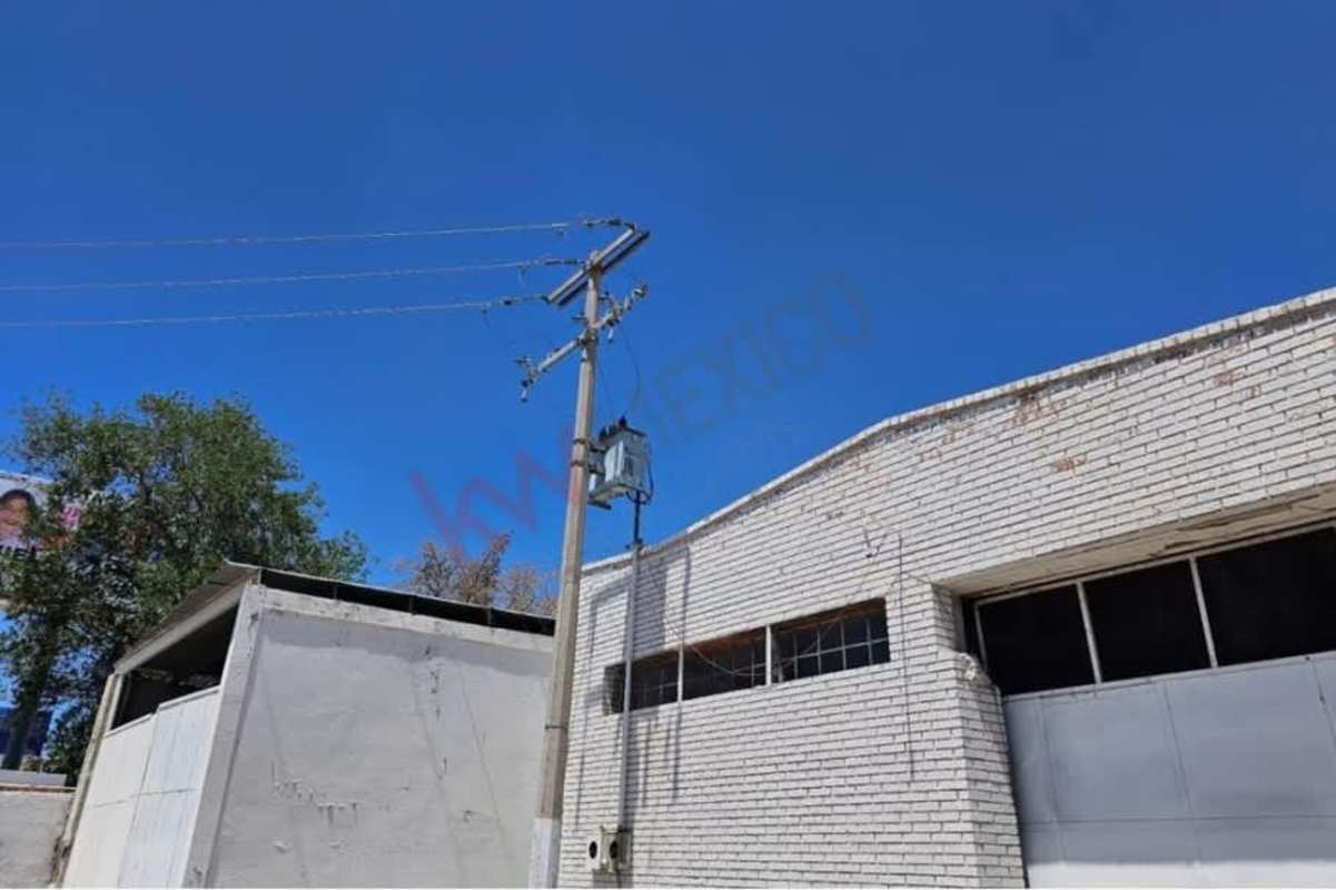 Exterior facade of industrial warehouse with garage doors and secure entrance on Avenida de la Raza Mexico