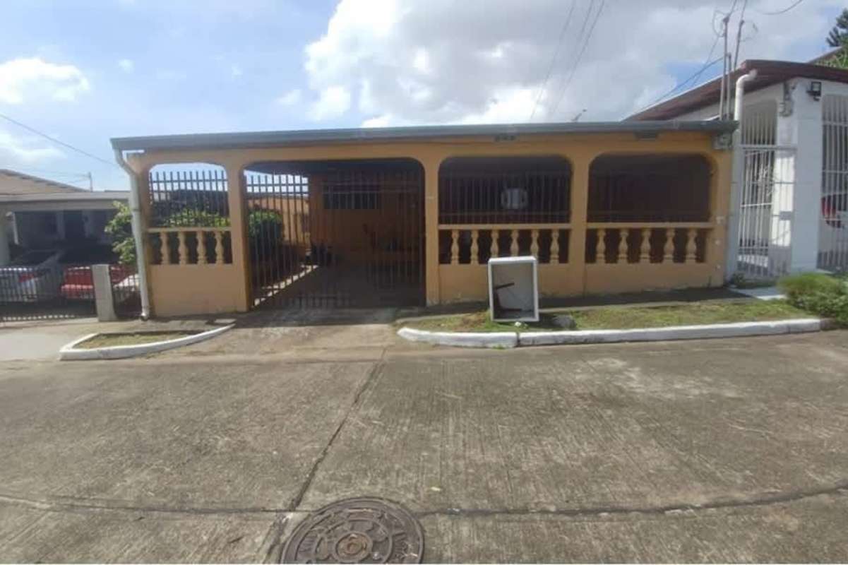 Covered carport area with metal gate entrance on a single-family house in Cerro Viento, Panama.