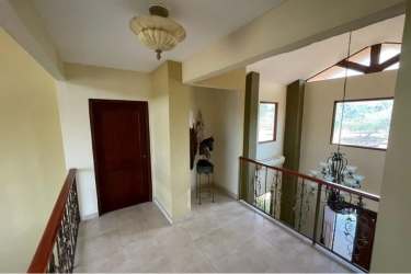Impressive entrance hall with chandelier, ornate wood ceiling and curved stairs in luxury estate in Panama Oeste