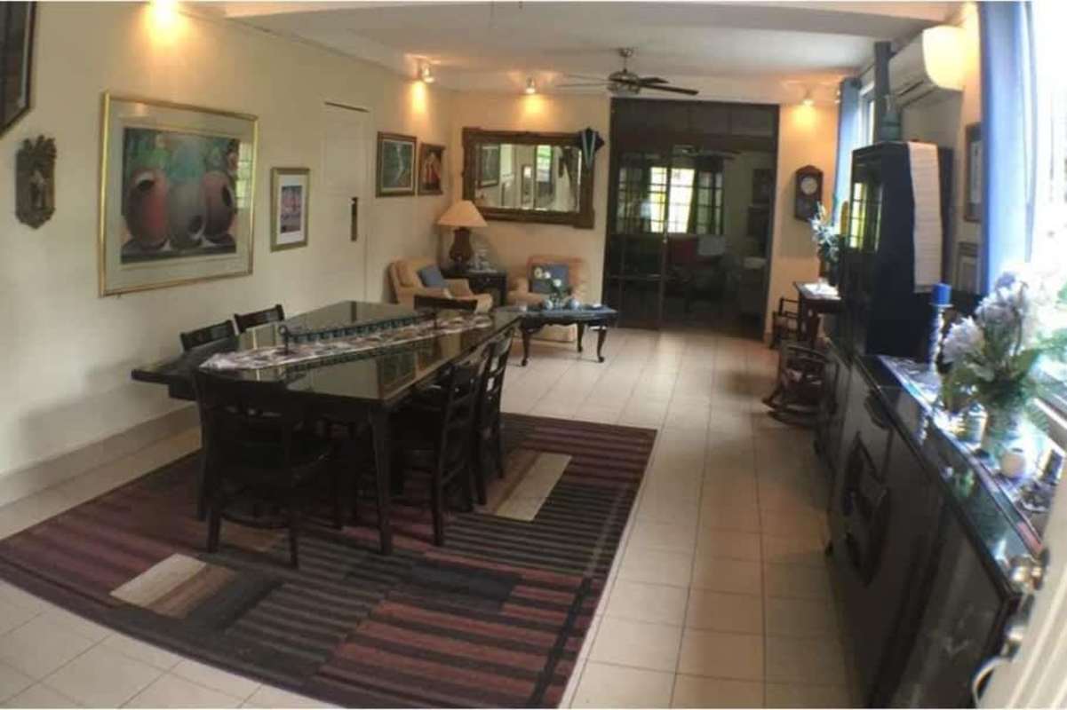 Bright open-plan living and dining room with large windows at house in Diablo Ancón Panama City