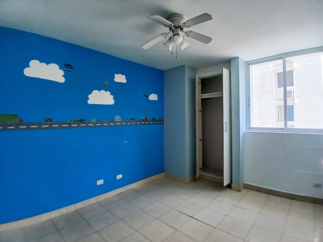 Bright kitchen with pass-through window, white cabinets in Edison Park Panama condo