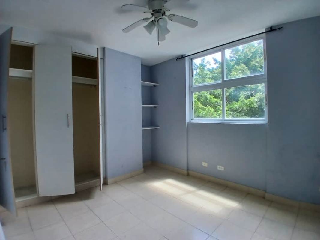 Bedroom with open closet and view of trees in Edison Park Panama City
