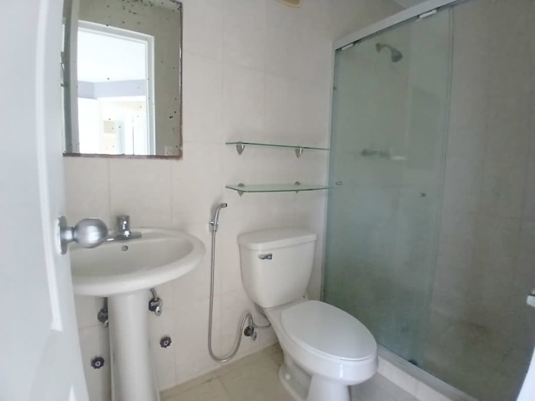 Bright bathroom with glass shower enclosure and pedestal sink in Edison Park Tower Panama