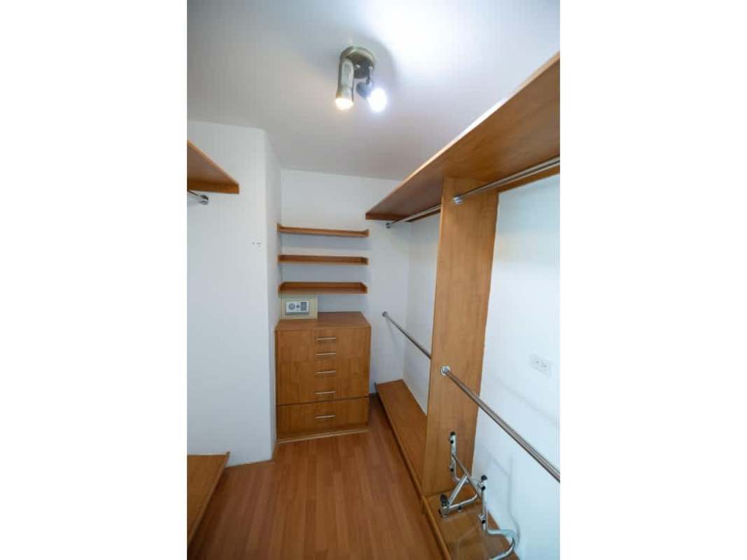 Contemporary walk-in closet with safe and wooden cabinetry PH Ocean Club Punta Pacifica