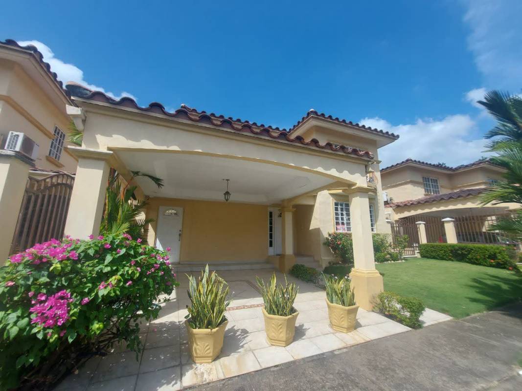 Two-story living room with mezzanine, red sofas, large windows and ornate railings in Condado del Rey