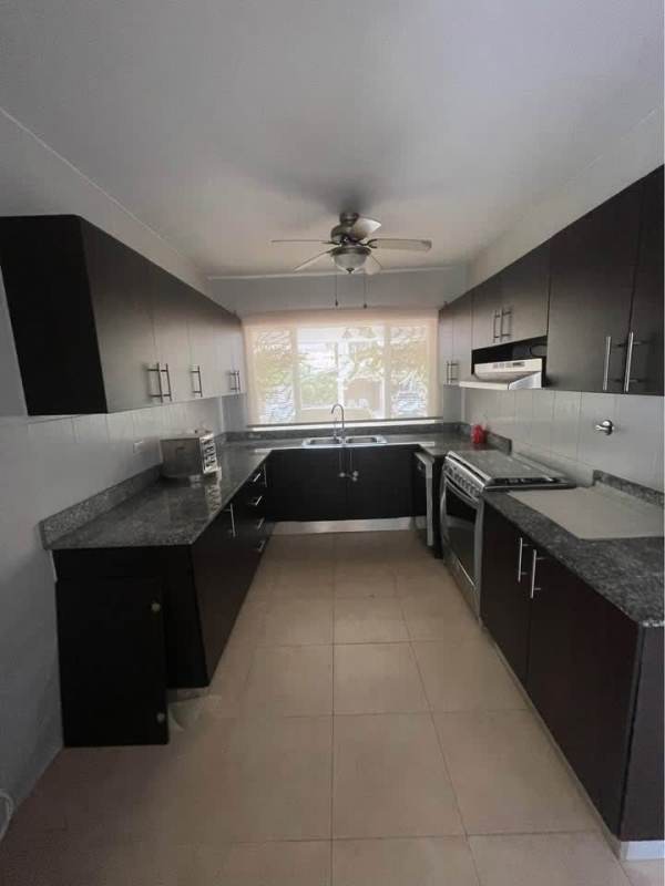 Modern kitchen with granite counters, dark cabinets and stainless appliances in Panama house