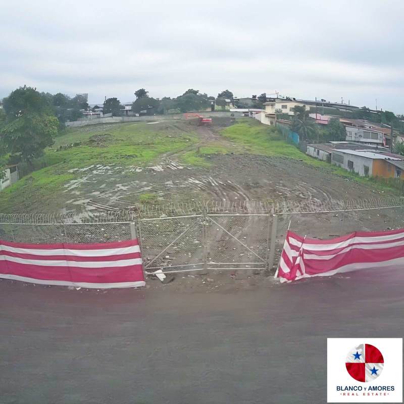 Urban land with metal fence surrounded by residential and commercial buildings ready for industrial development Panama
