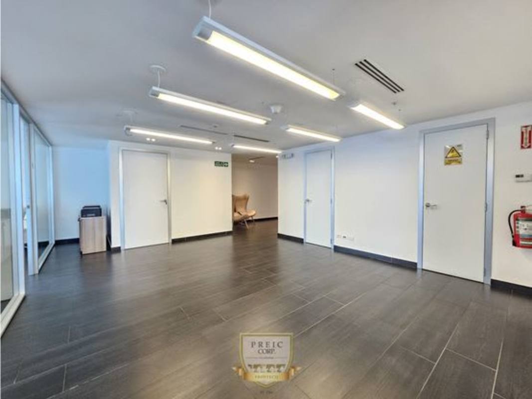 Lobby or waiting area of modern office with tile floors and lounge chair at Oceania Business Plaza