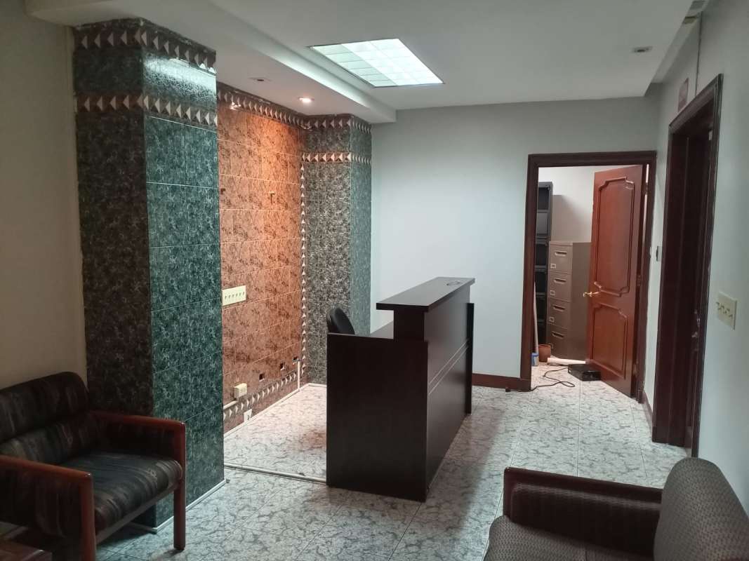 Reception area with tiled columns, wood reception counter, TV and decor in PH BICSA Tower Panama City