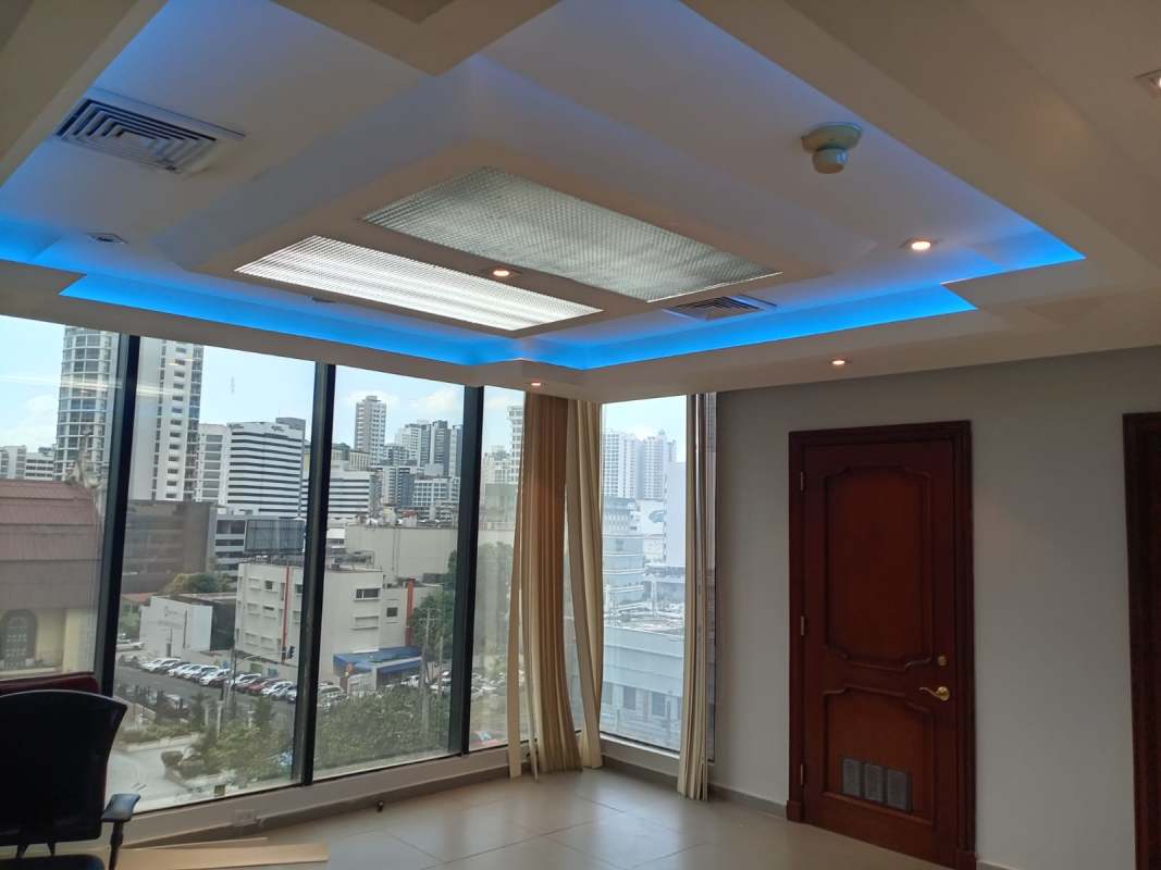 Executive office space with panoramic windows overlooking Panama City skyline and blue ceiling detail