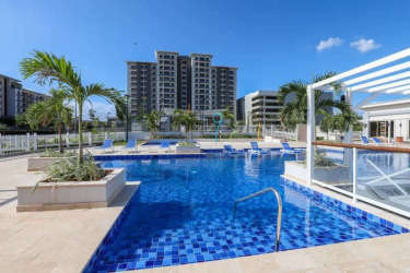 Swimming pool with lounge chairs and palm trees in PH Parterre Panama Pacifico