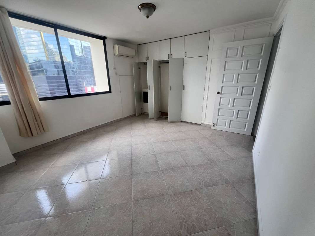 Empty bedroom featuring large window, built-in closet and AC in Bella Vista Panama