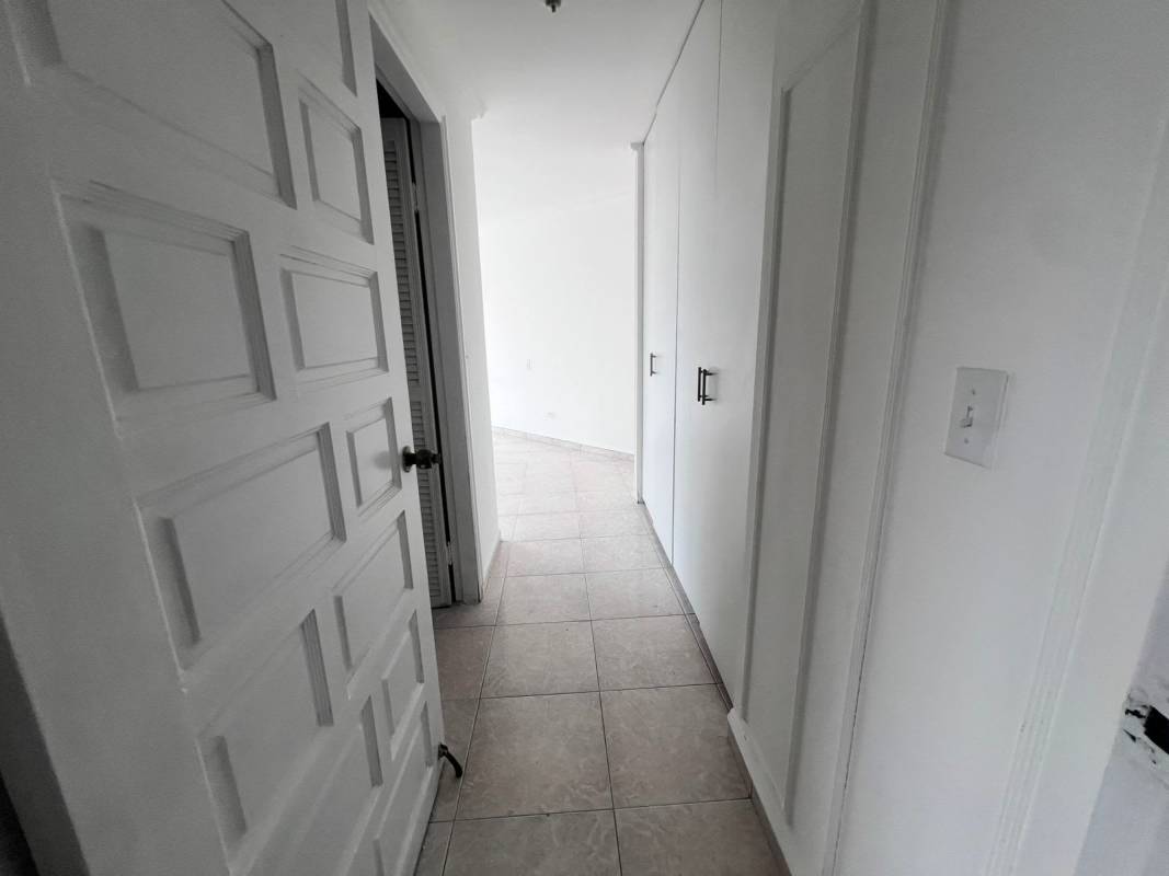 Minimalist hallway with built-in closets and ceramic tile floor in Panama apartment