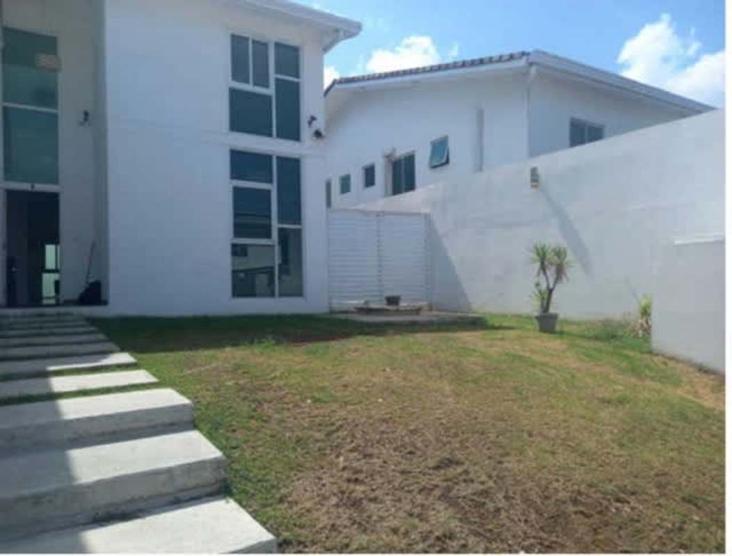 White two-story home with fenced yard and patio in PH Horizonte II Panama City