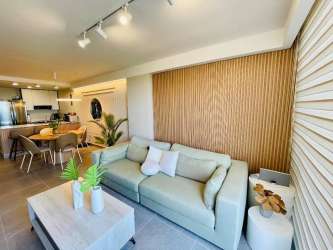 Open-concept living and dining room with ocean view large window at PH The Palms El Palmar Panama