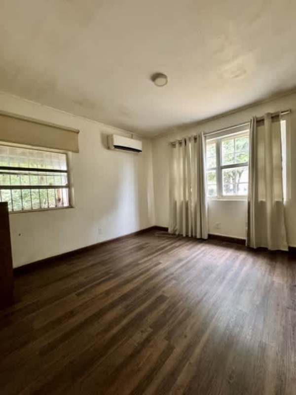 Living room with large windows, split AC, wood floors overlooking gardens in Clayton apartment