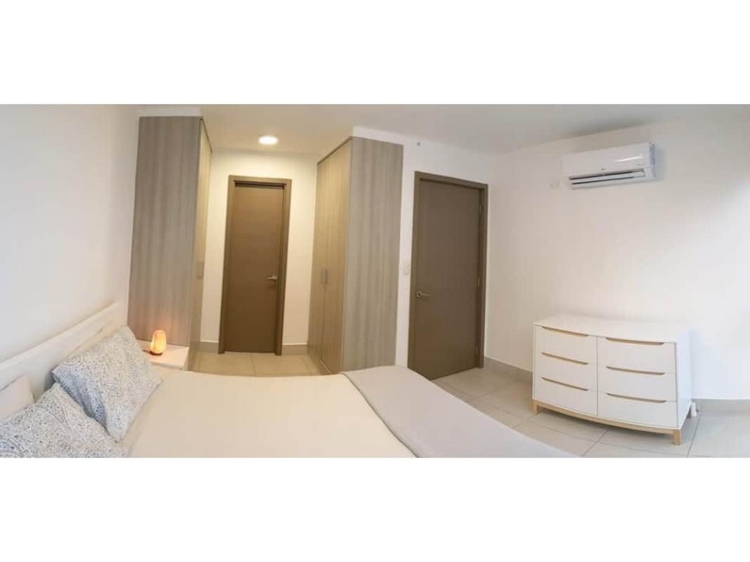 Open layout kitchen with island and white cabinets at PH Park City Panama City