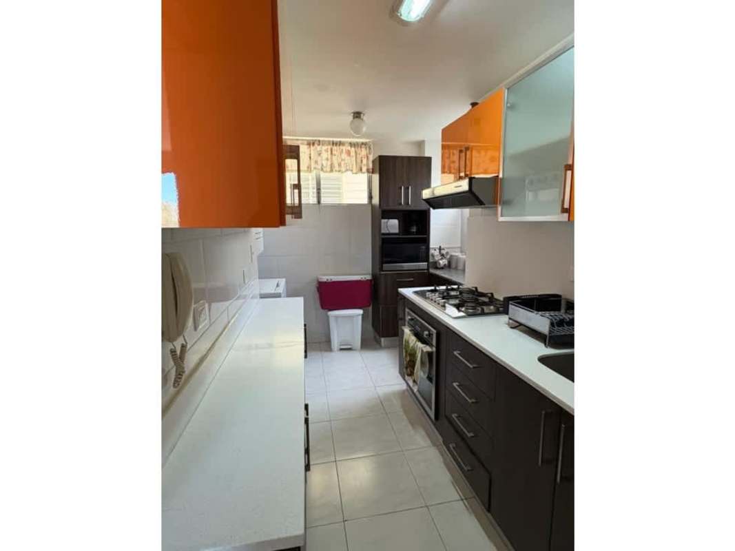Orange and brown cabinets, stove, refrigerator, tiled kitchen PH McGregor Condado del Rey