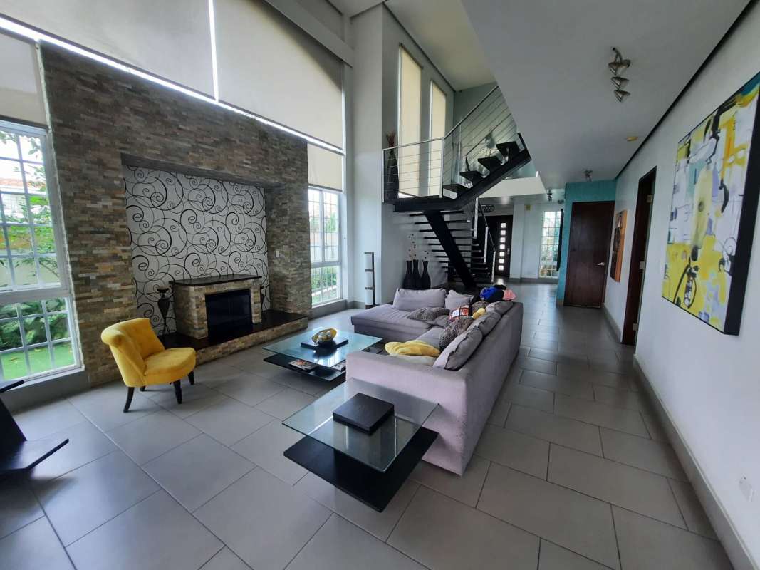 Family room with large windows, spiral staircase, wall art and modern design at luxurious Altos de Panamá house