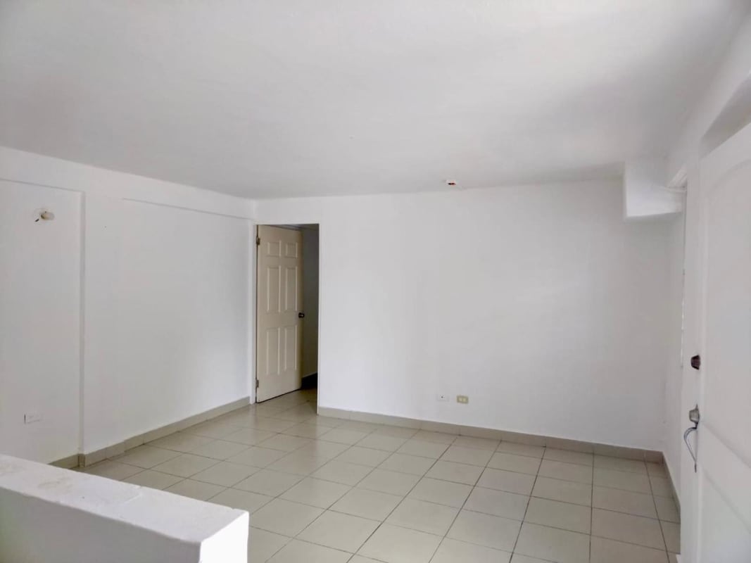 Two-story cream color building with exterior staircase, gated entrance and parking in Rio Abajo apartment for rent