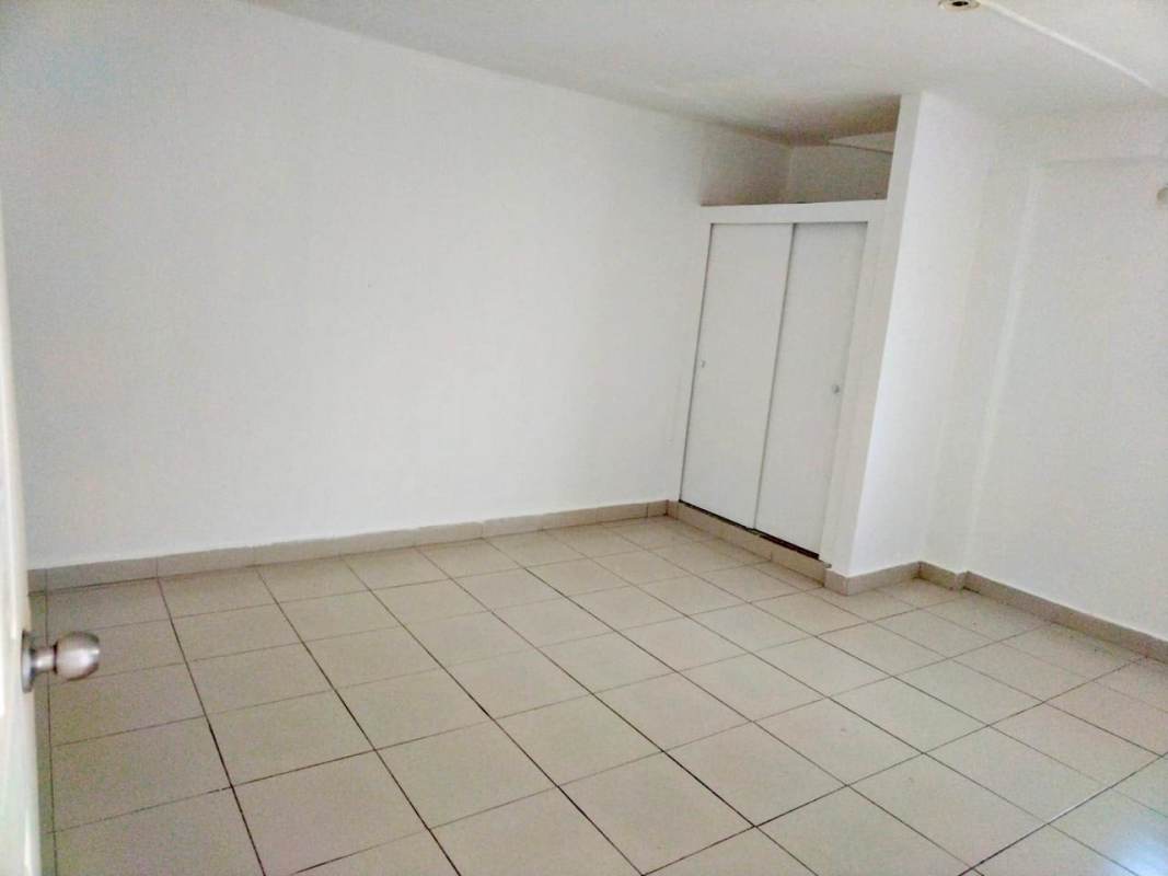 Bedroom with ceramic tiled floor, built-in closet with sliding doors in Rio Abajo apartment Panama City
