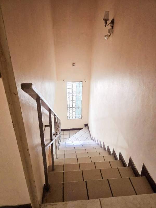 Interior staircase with tiled steps and metal handrail inside duplex house in Condado del Rey