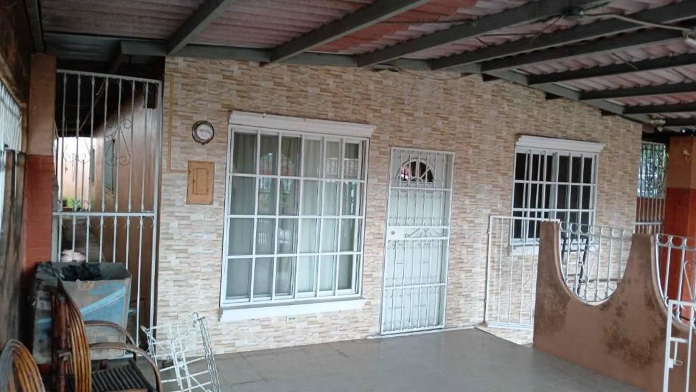 Covered entry patio with stone veneer wall, metal gate and tiled floor in Villa Licia Don Bosco Panama
